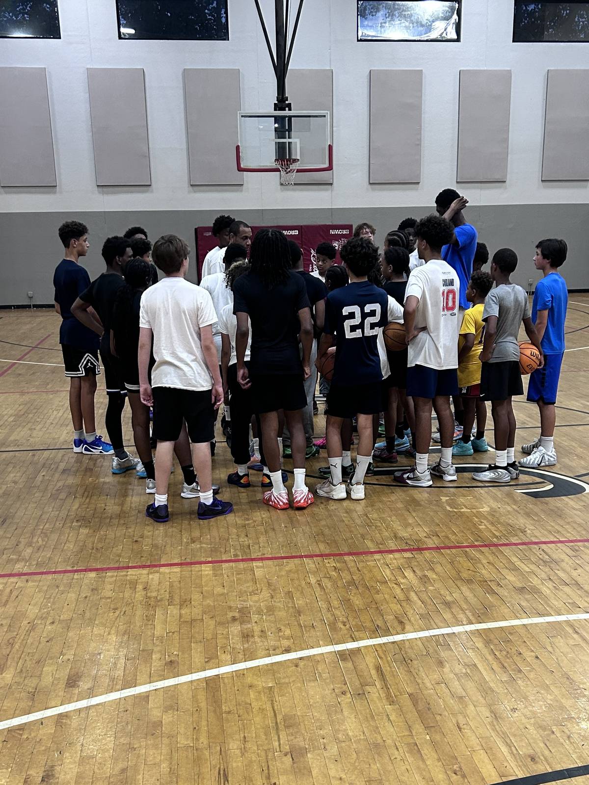 TRUE Blue Training Academy players huddled around their coach on a Chicago basketball court